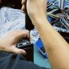 Tecnico impegnato nel collaudo al banco di un quadro strumenti digitale specifico per un determinato veicolo durante la revisione in garanzia