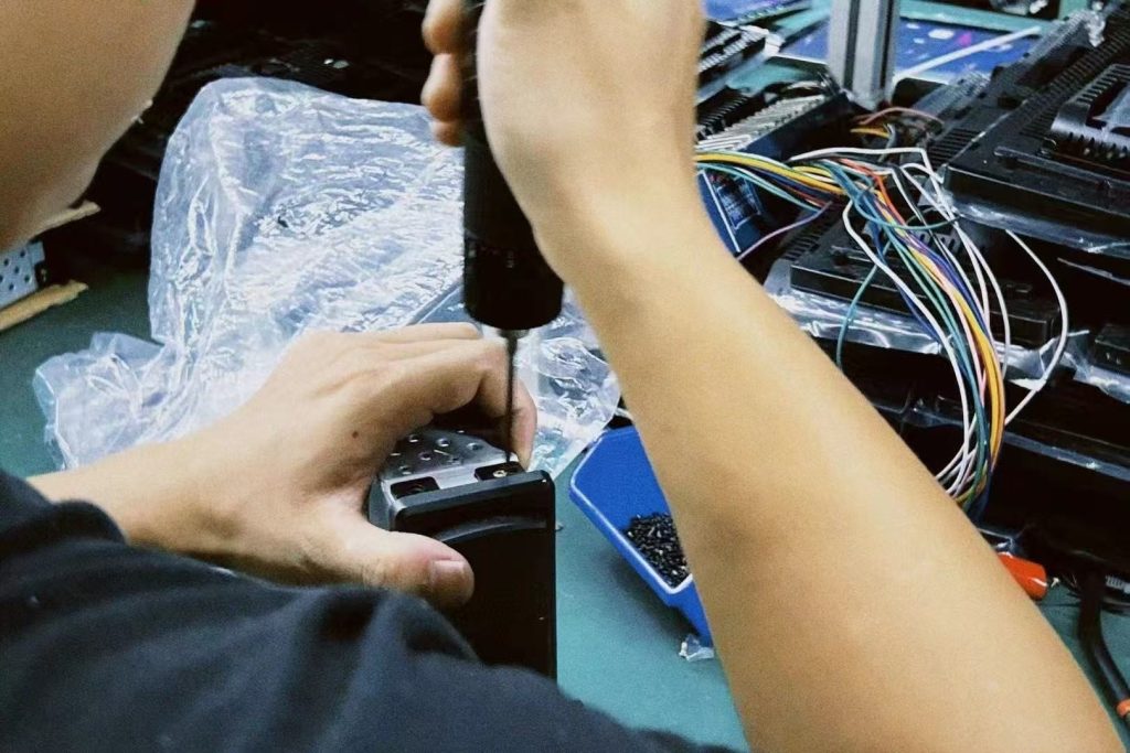 Tecnico impegnato nel collaudo al banco di un quadro strumenti digitale specifico per un determinato veicolo durante la revisione in garanzia